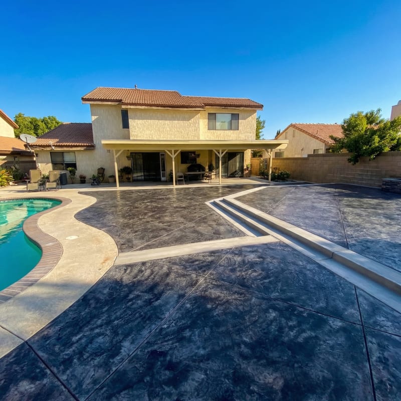 Stamped concrete pool deck with a dark slate finish