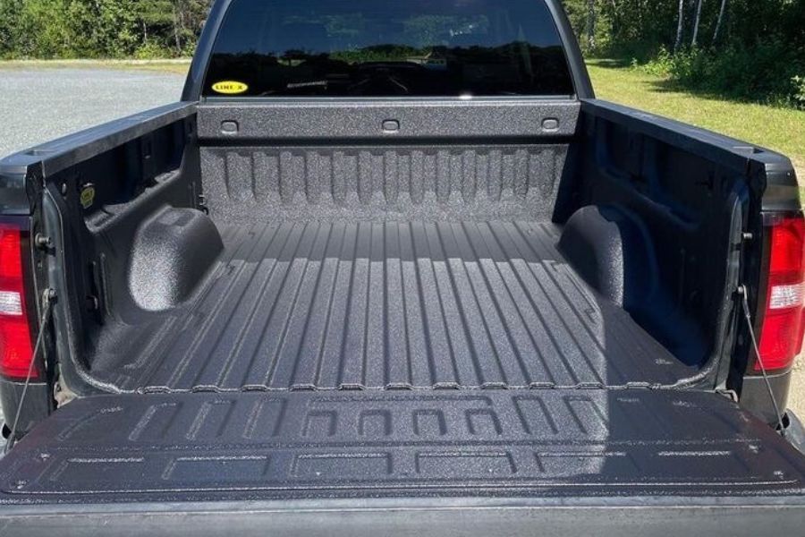 applying spray-on bedliner Line-X to custom truck bed
