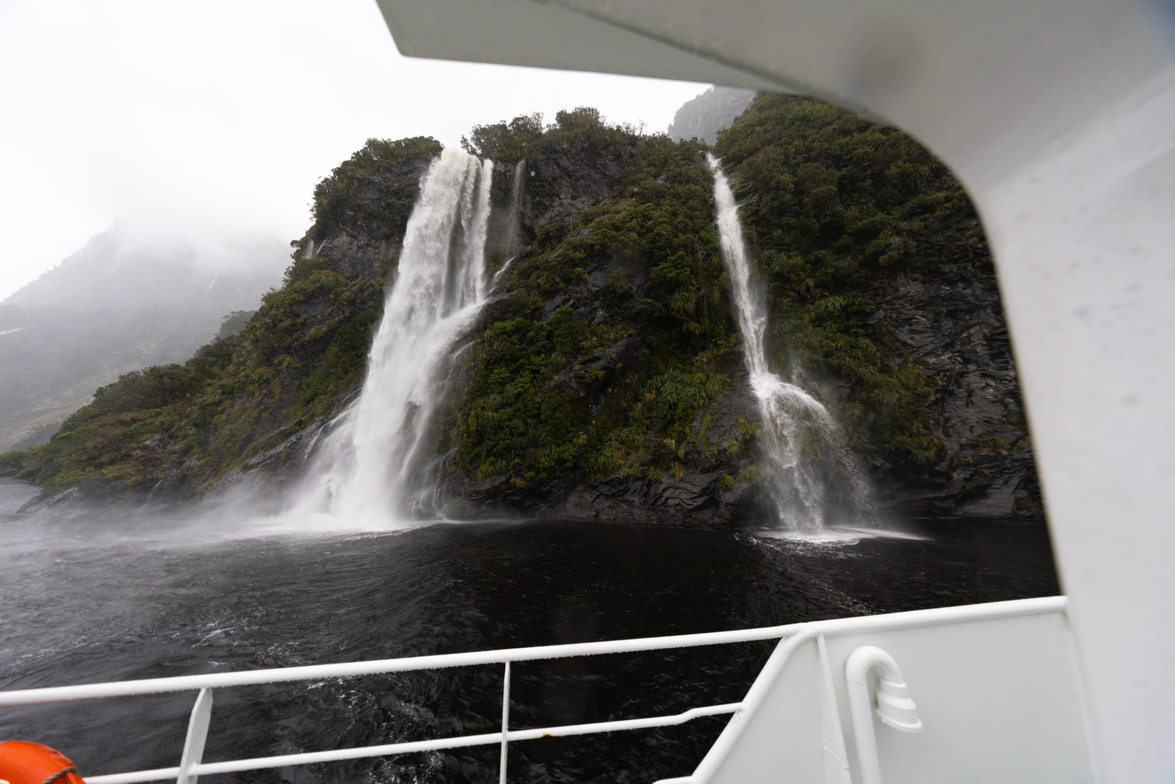 MV Tutoko II encountering a waterfall in Doubtful Sound, Fiordland Expeditions overnight cruise