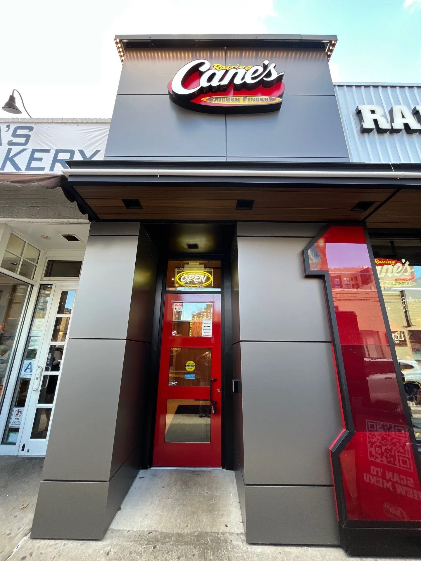 Glass restaurant entrance at Raising Cane’s Forest Hills