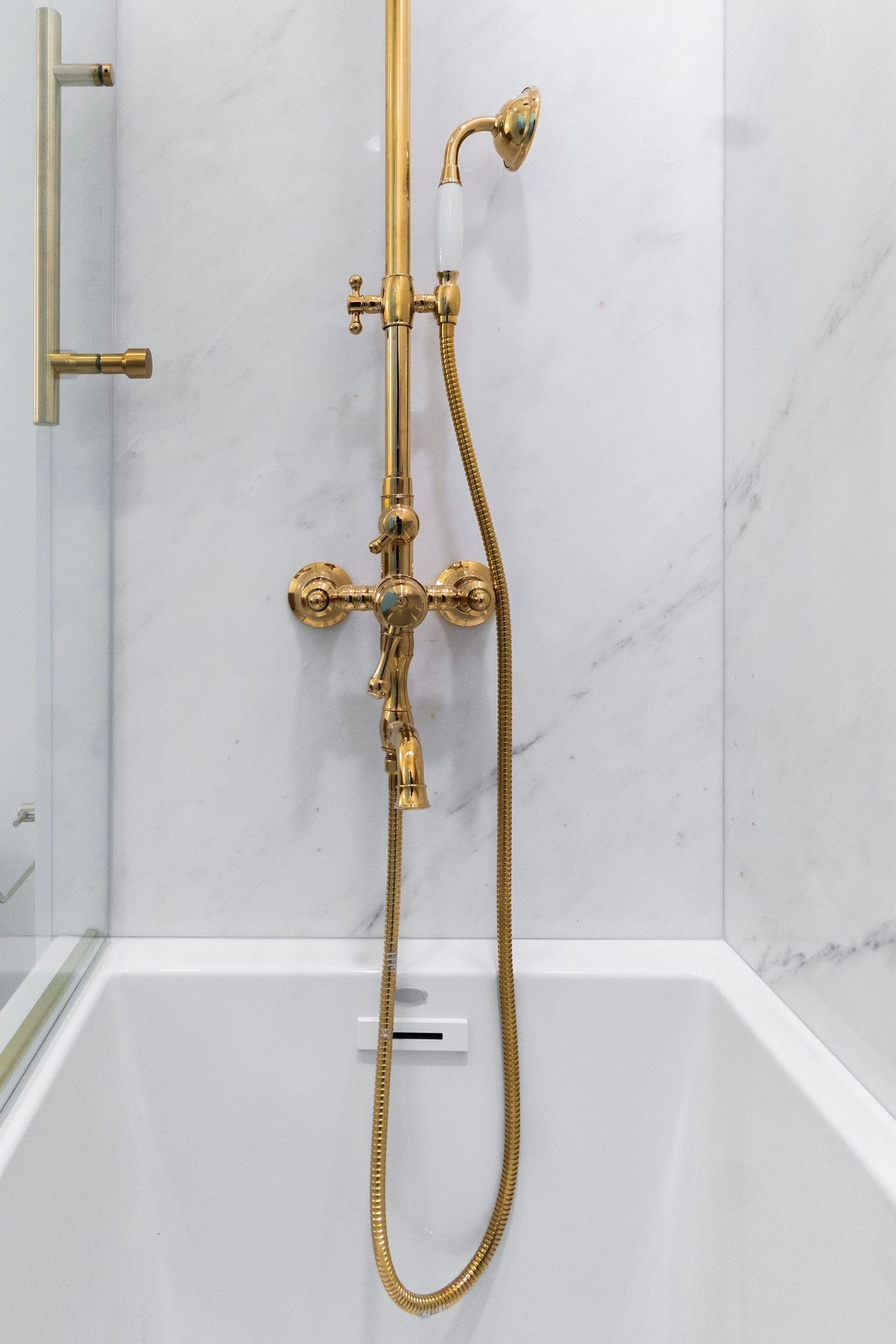 Brass shower fittings against the tiled wall
