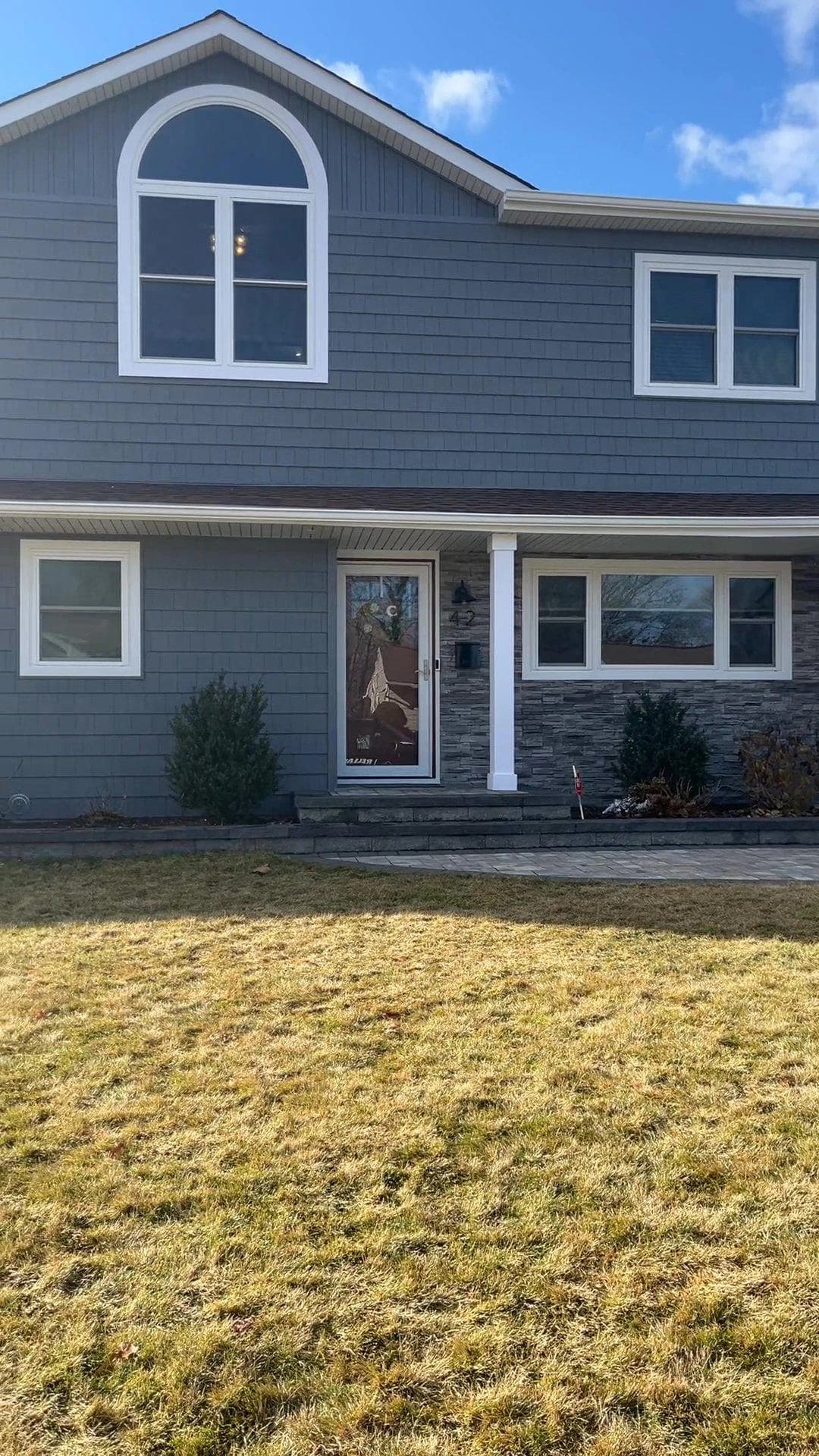 Front facade with new siding, windows and stone finishes