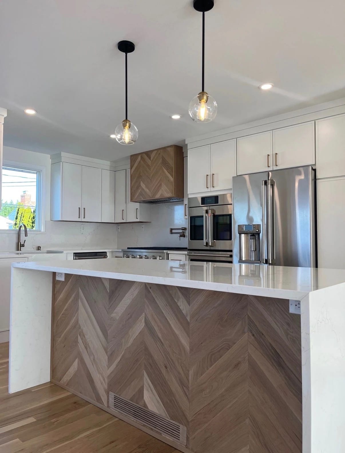 Kitchen lighting and custom accent at island with waterfall quartz countertop