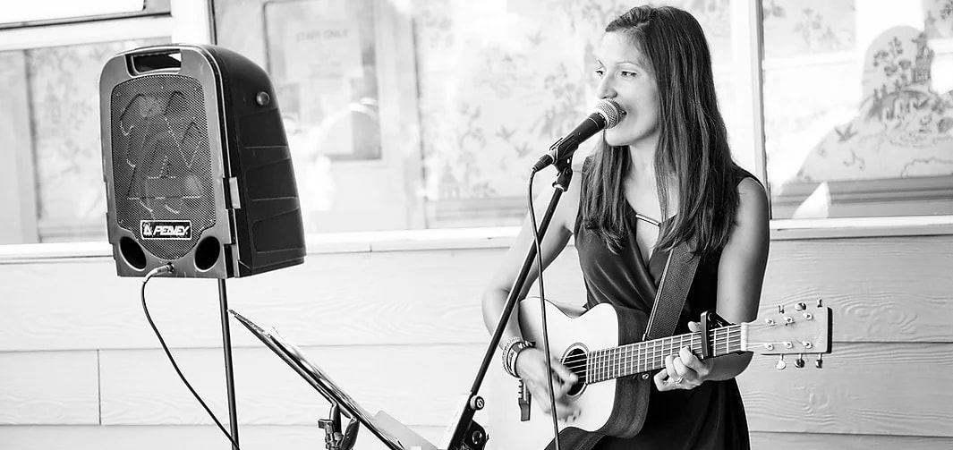 black and white photo of nina singing and playing guitar