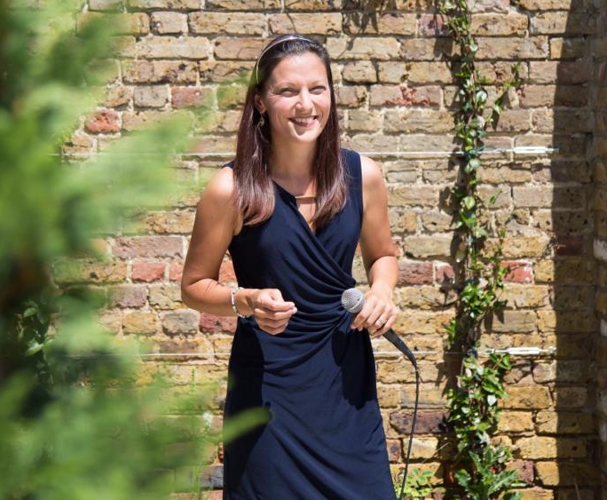 photo of Nina smiling at an outdoors wedding ceremony