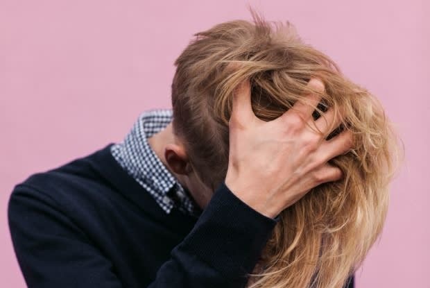 a young man running his hand through his hair in distress