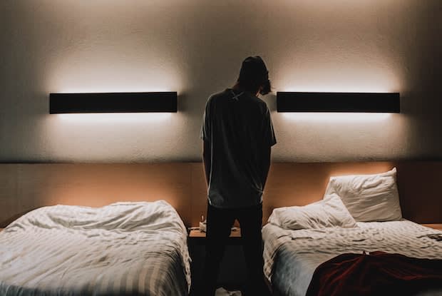 a man standing in between two beds