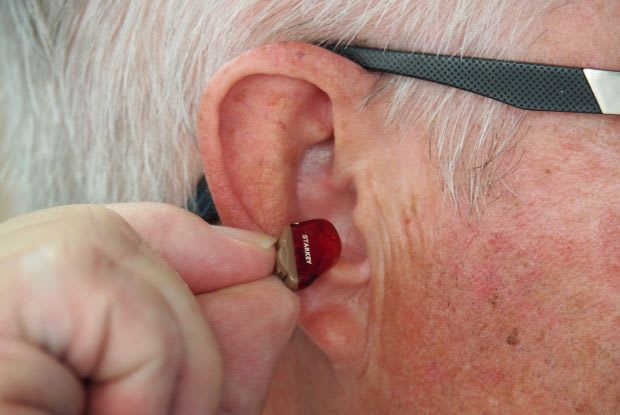 a man putting a hearing aid into his ear