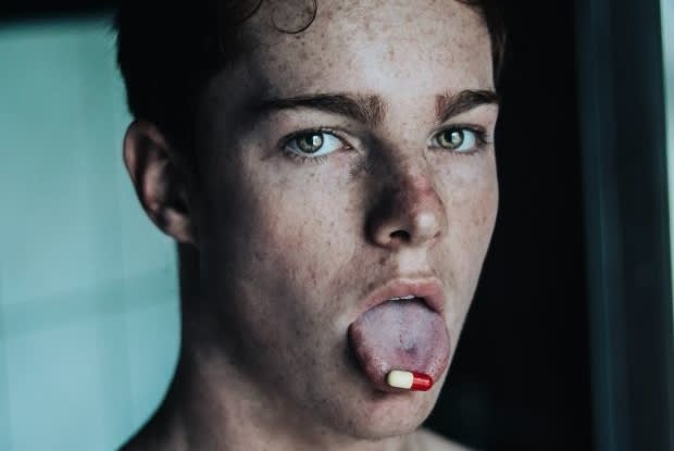 a man with a pill on his tongue