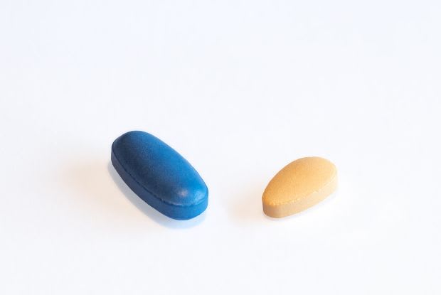 A Viagra tablet and a Cialis tablet on a white background