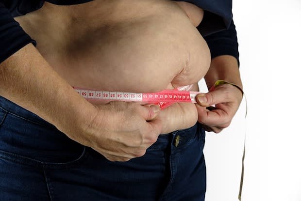 a person measuring their waist