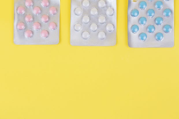 three packs of pills on a yellow background