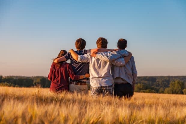 four people with their arms around each other