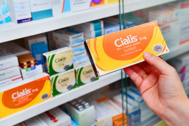 a person holding a box of ED medication