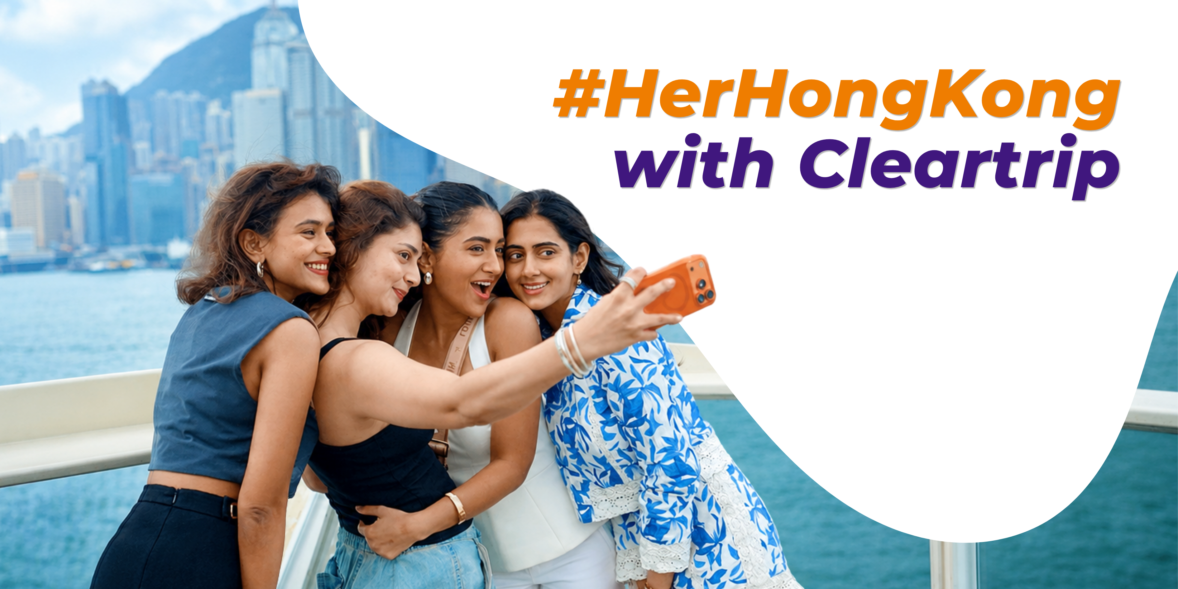 Four women taking a selfie against the Hong Kong skyline for the #HerHongKong campaign with Cleartrip