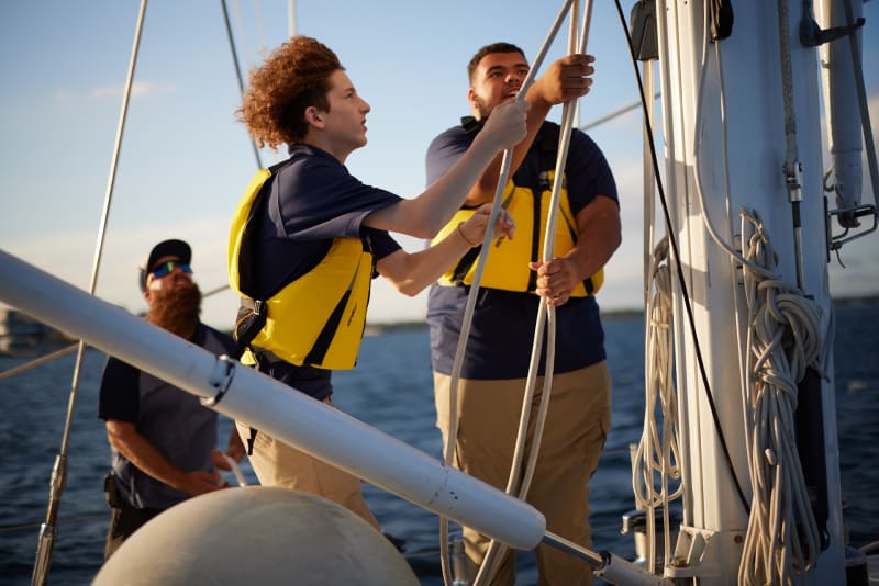 Students rigging the sails on deck