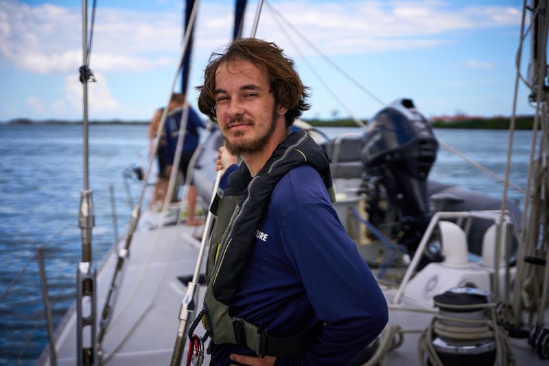 A sailor in a life vest on the deck of a boat