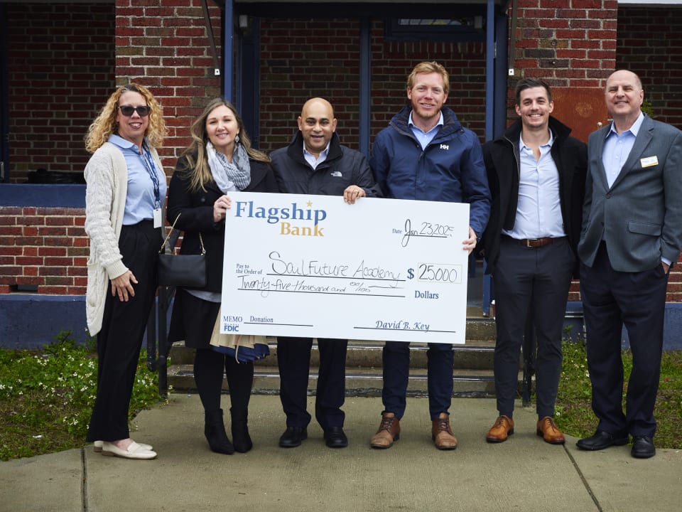 Community partners present a generous donation check to support SailFuture Academy programs.