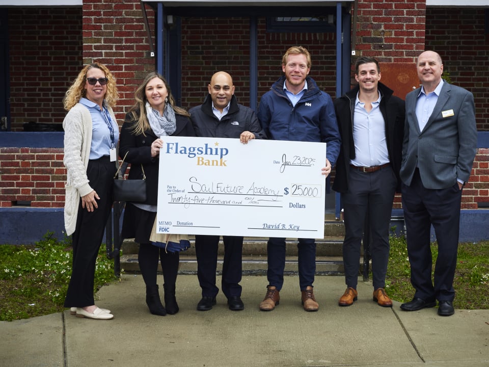 Representatives from Flagship Bank present a generous donation check to SailFuture Academy staff and supporters.