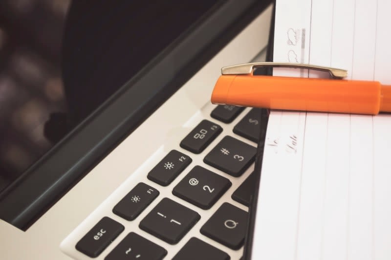 Pen and notebook on laptop keyboard