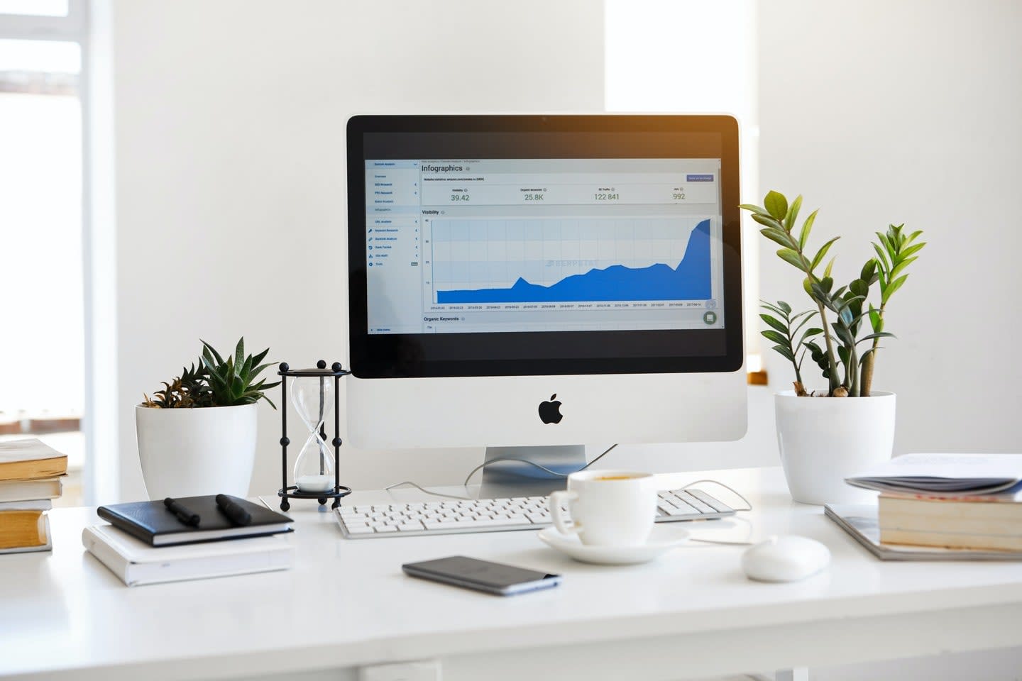 iMac desktop computer on work table with potted plants