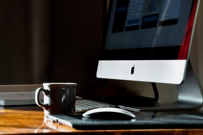 iMac desktop computer with black coffee mug