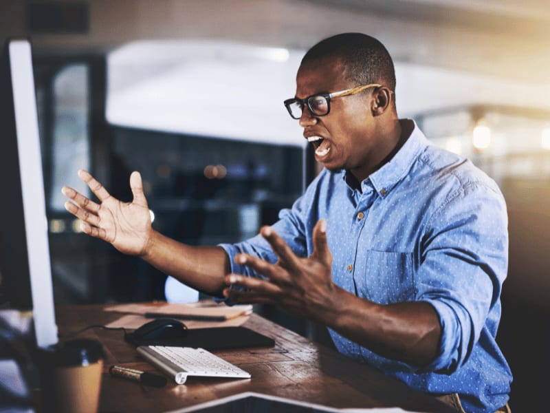 Frustrated man yelling at computer screen