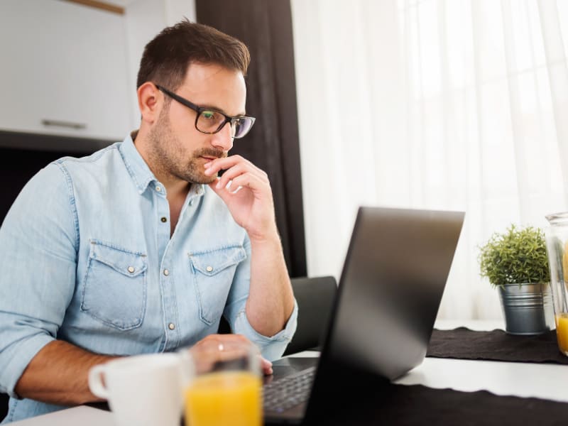 Man troubleshooting missing or corrupted icons on a laptop at home