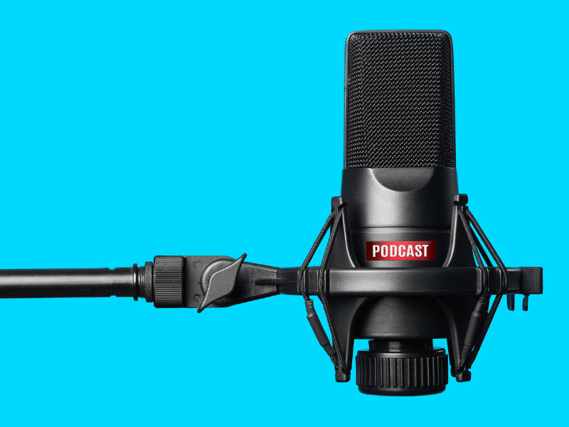 Black podcast microphone on a blue background, highlighting podcasting or professional audio recording equipment.