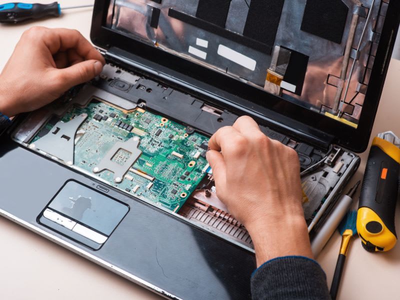 Close-up of a laptop’s internal components being repaired by a technician.