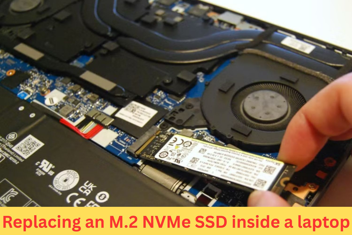 Close-up of a person replacing an M.2 NVMe SSD inside a laptop, showing internal components like the battery, fan, and motherboard.