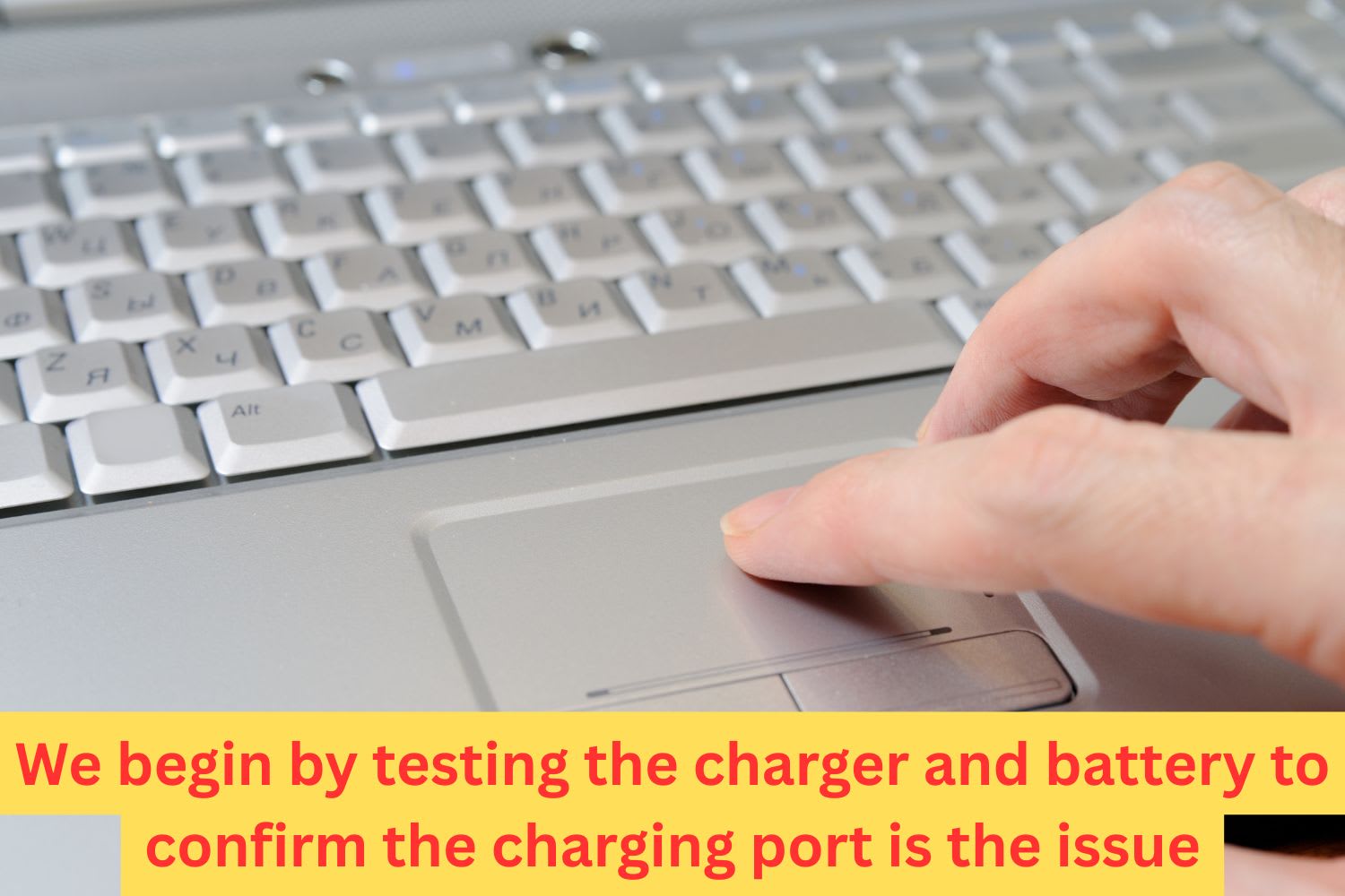 Close-up of a user pressing a laptop touchpad to begin testing and confirm whether the charging issue is related to the port or battery.