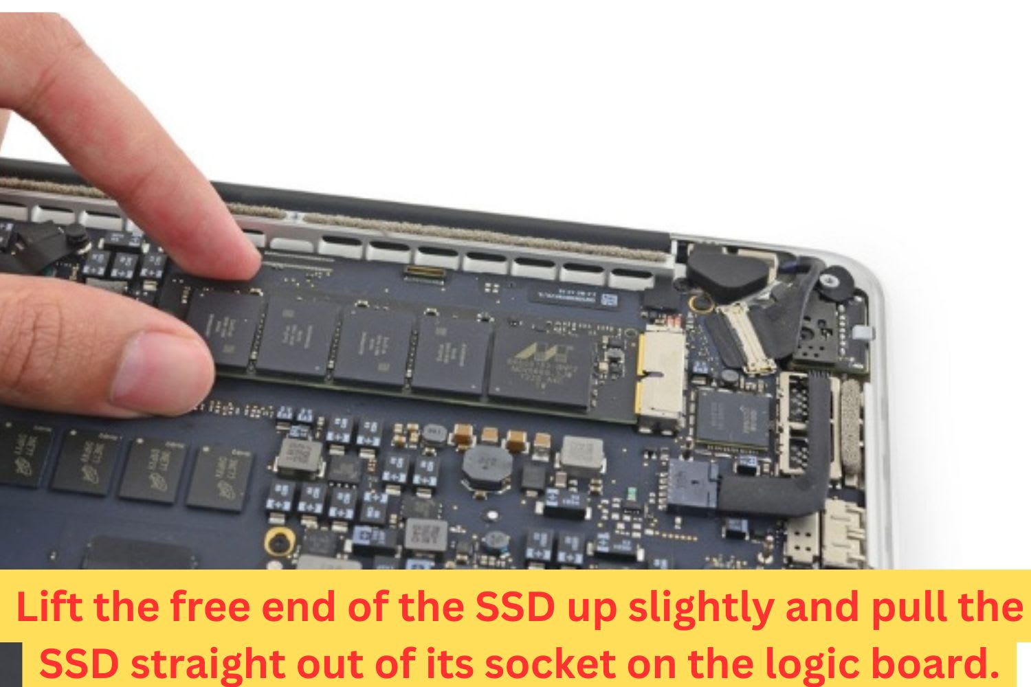 Close-up of a technician lifting the SSD from a MacBook logic board during solid-state drive replacement or upgrade