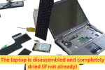Old laptop completely disassembled on the floor with keyboard, hard drive, battery, and internal components laid out for water damage inspection.