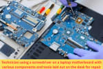 Technician using tools to work on a laptop motherboard surrounded by parts and screwdrivers during motherboard repair.