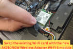 Close-up of a user swapping out the existing Wi-Fi card on a laptop motherboard with an Intel AX210NGW Wi-Fi 6 adapter for faster wireless connectivity.