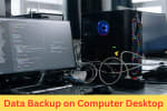 Desktop computer setup with multiple monitors, cables, and active data backup process, showing secure data storage on PC