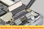 Close-up of a MacBook charging port being replaced, showing the connector and internal port components