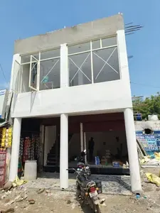 "Two-story commercial building with a ground-floor shop for rent in Gurgaon, featuring a spacious storefront, upper-floor office space, and roadside visibility ideal for retail or business use."