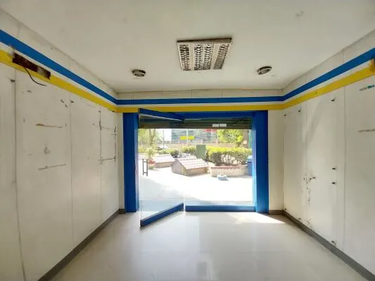 "Empty shop for rent in Gurgaon featuring a glass storefront, tiled flooring, bright interiors, and a prime location suitable for retail or commercial business."