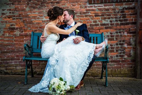 Newly wed couple kissing on park bench