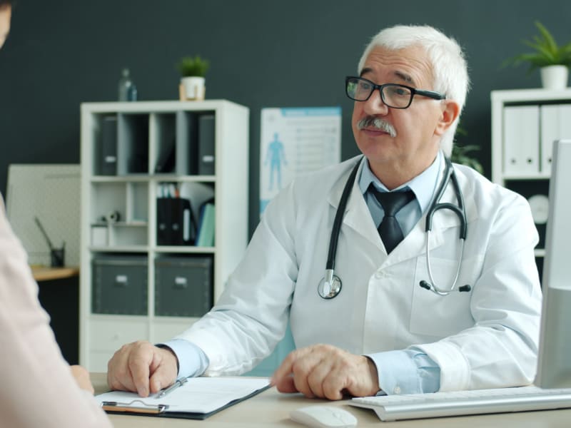 Doctor discussing prostate treatment options with a patient in a medical office