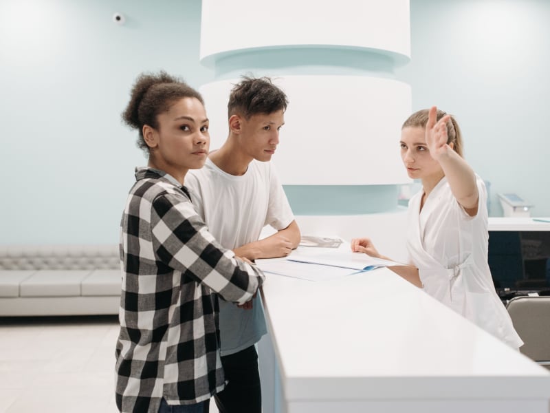 Patients checking in at a hospital reception desk where BPH procedure billing and facility fees are processed