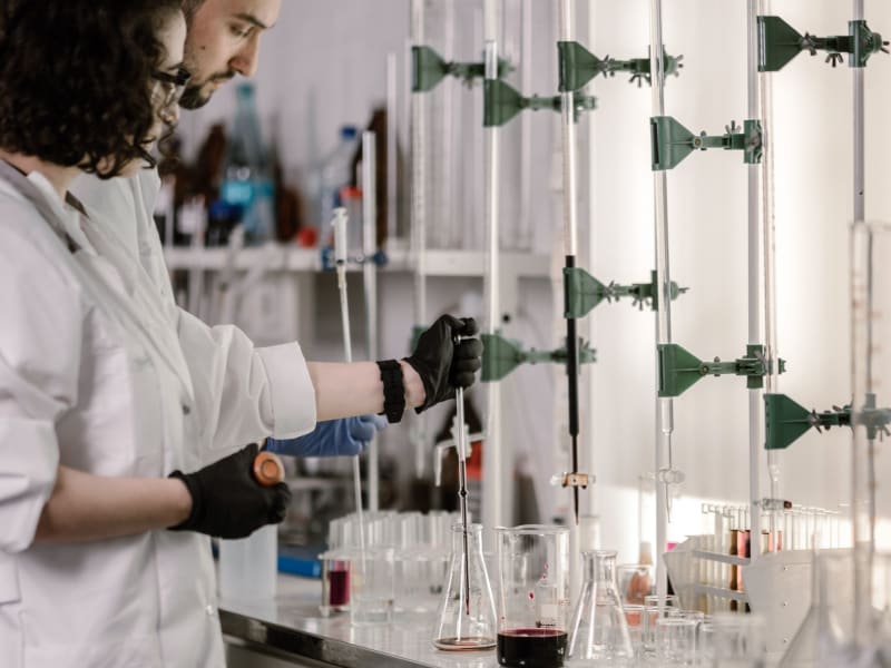 Scientists in lab coats handling test tubes and samples in a modern laboratory