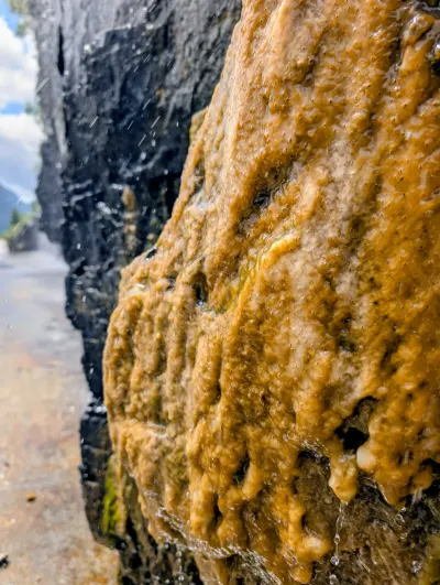 Closeup of mineral deposits on a roadside waterfall