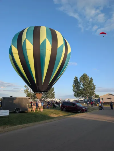 Hot Air Balloon with a powered parachute airborne in the distance