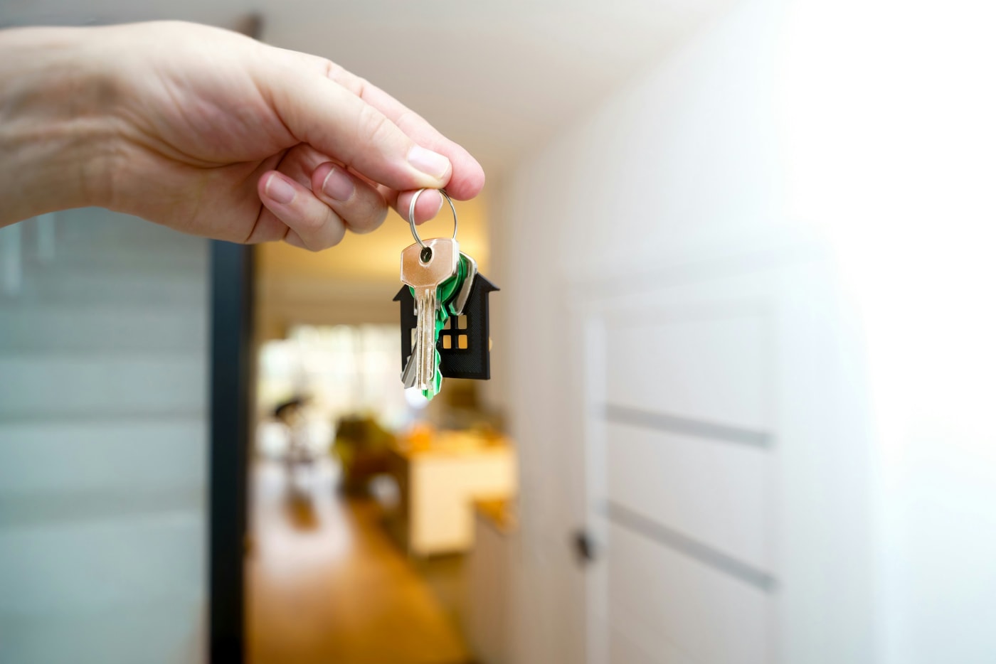 A hand holding house keys in a new home