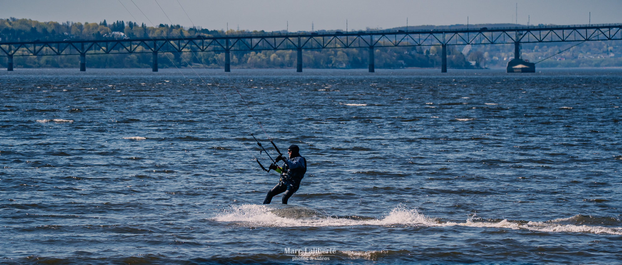 Le vent emporte un kitesurfeur sur le fleuve Saint-Laurent, sous le regard de l'île d'Orléans.
