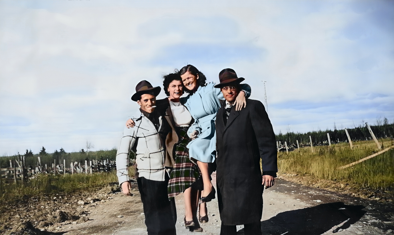Photo restaurée et colorizée de deux couples qui posent amicalement sur une route de compagne