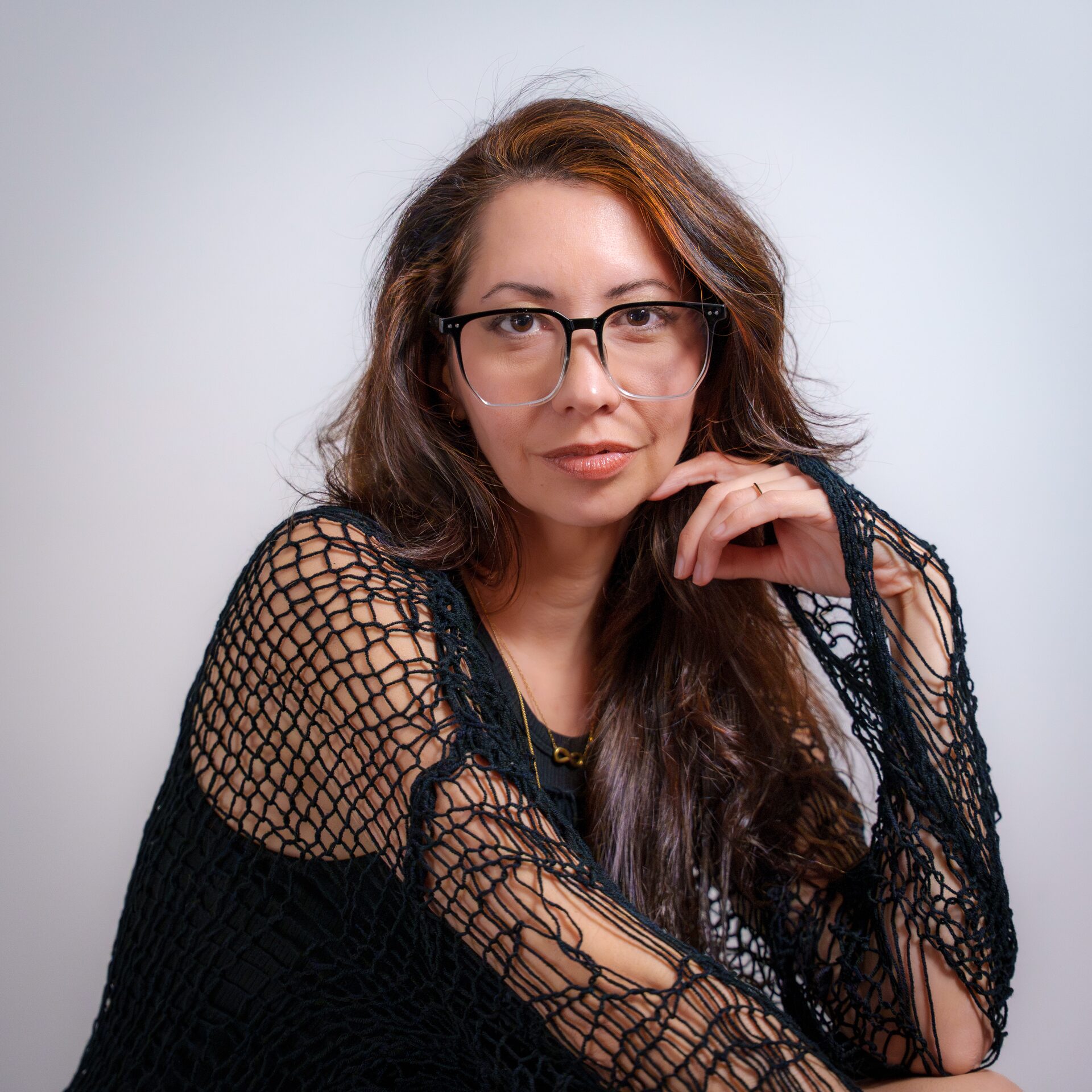 Portrait d'une femme avec lunettes et haut en filet noir en studio